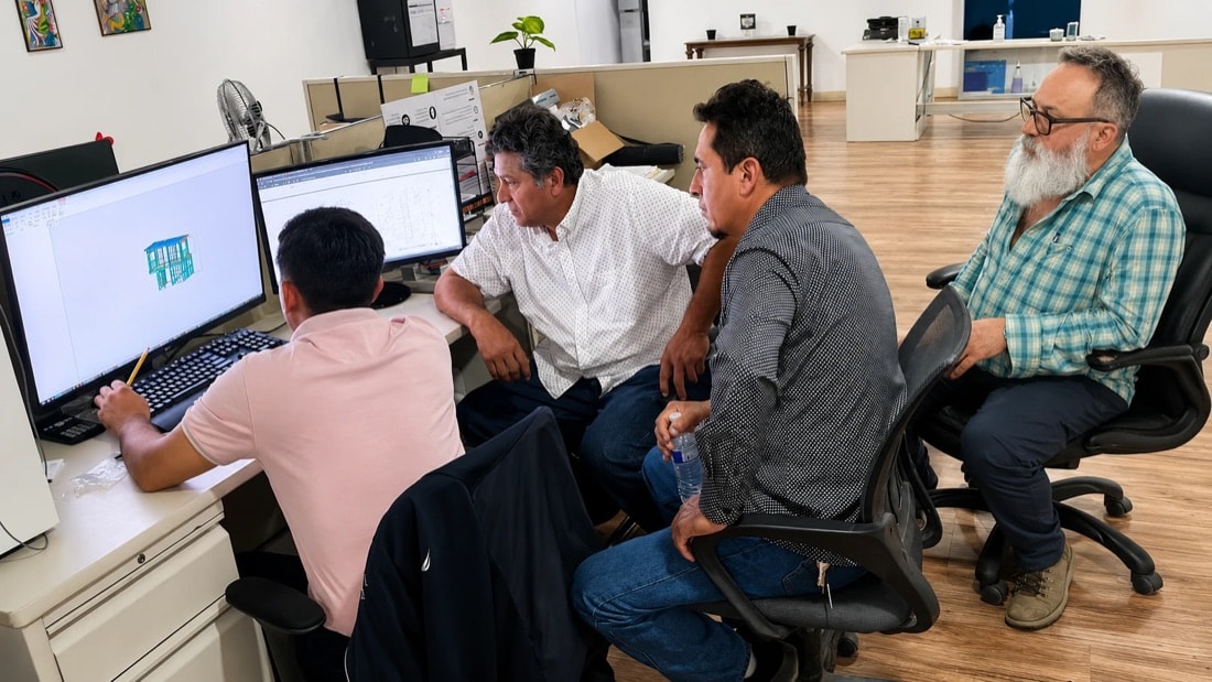 TESH engineering team reviewing a BIM model of a steel structure on screen in the office