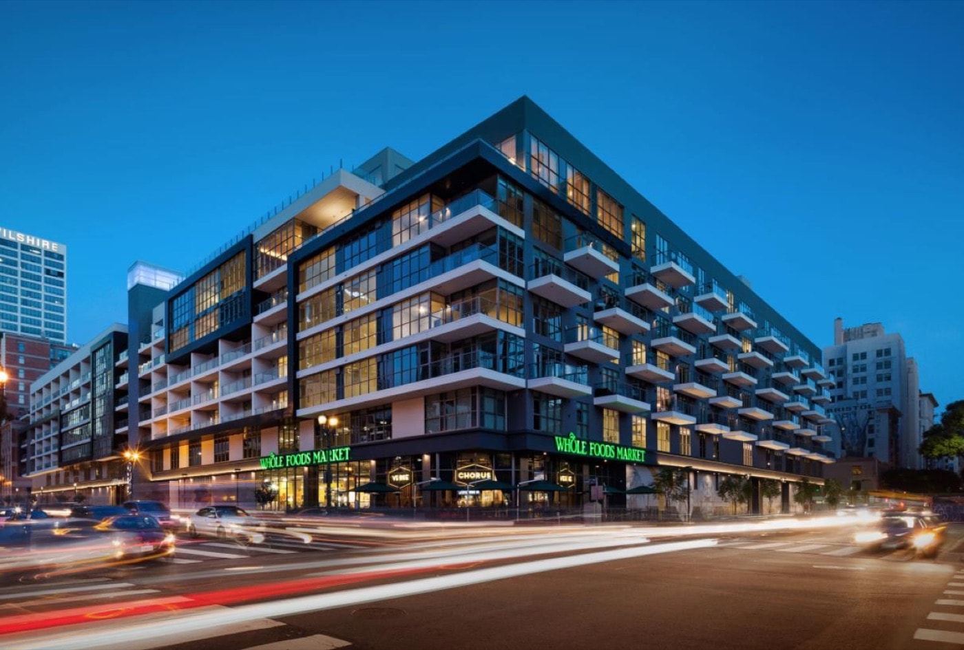 The completed 8th and Grand mid-rise multifamily building in downtown Los Angeles at dusk.