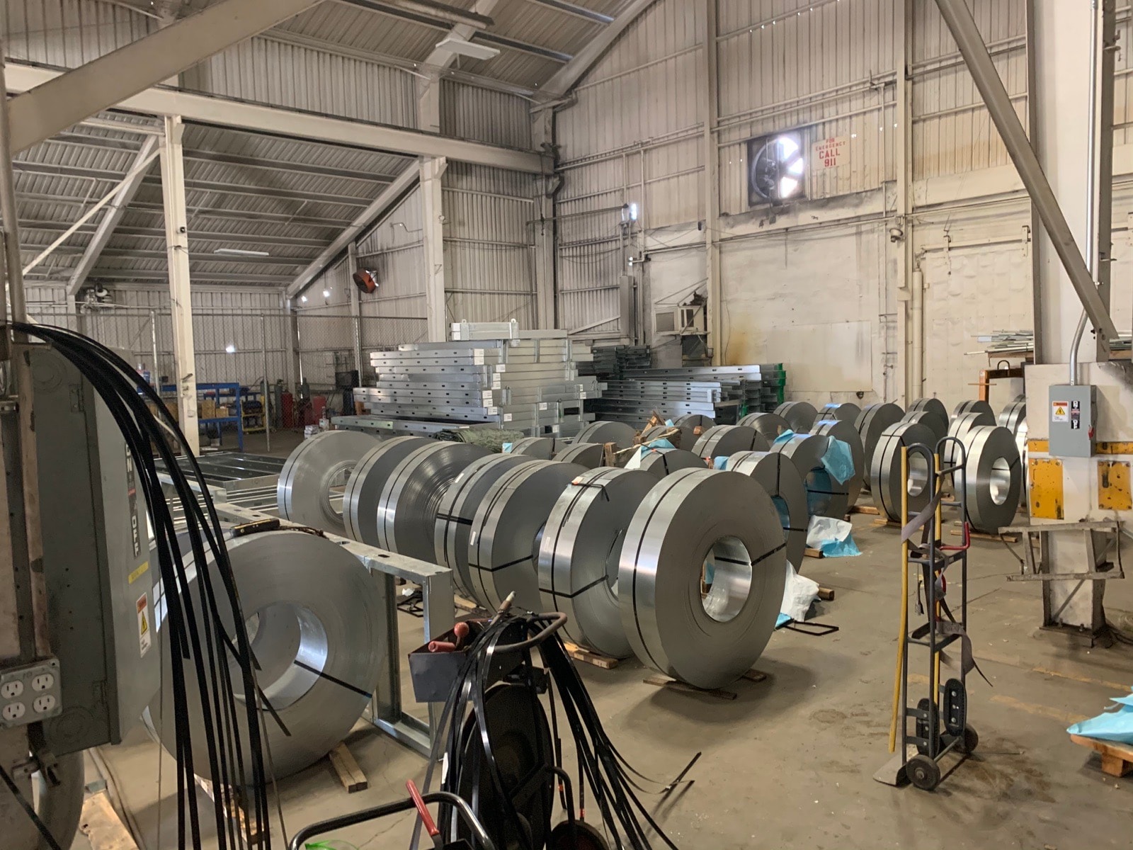 Master steel coils staged on the slitting line at the light gauge steel facility.