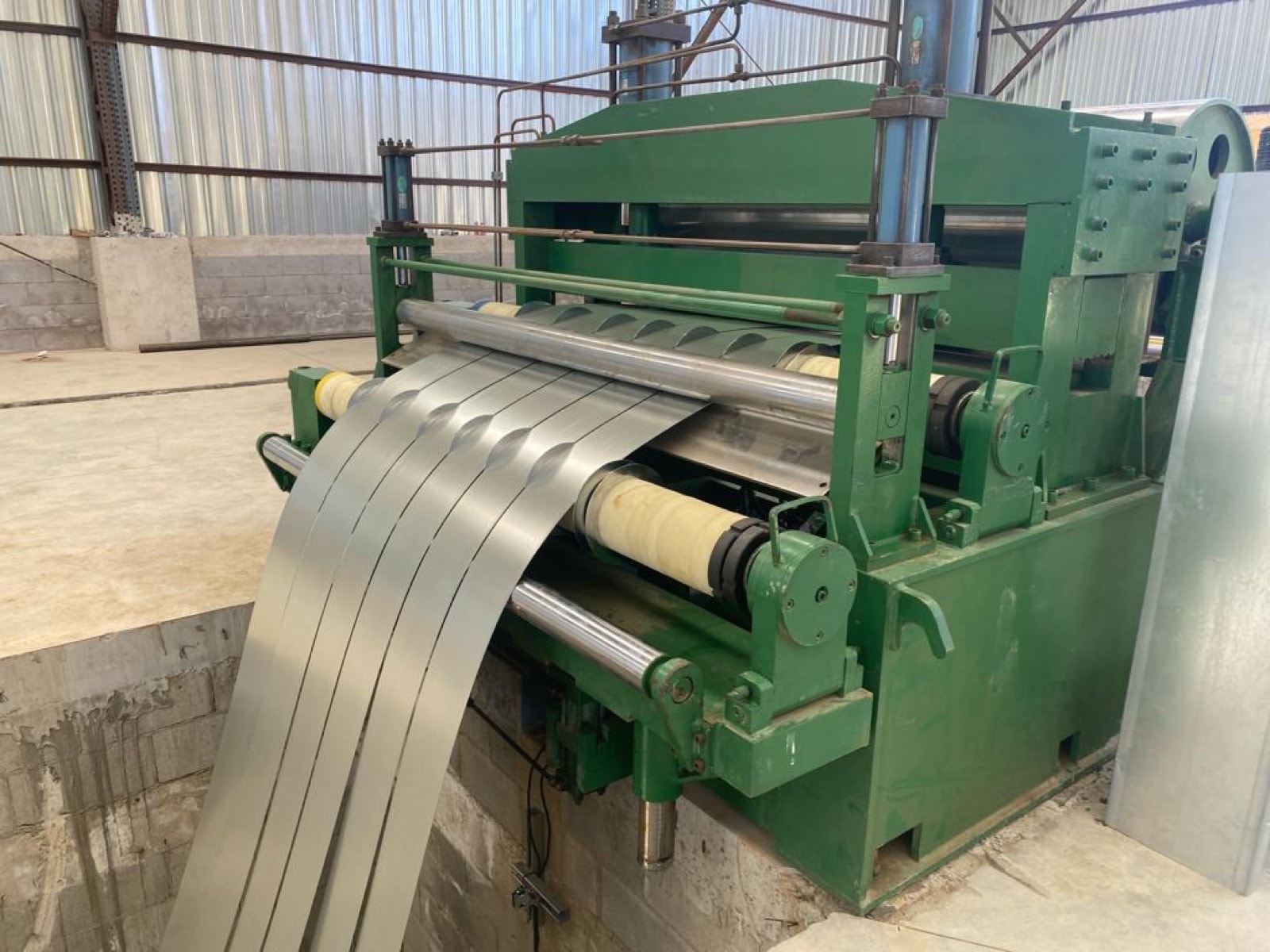 Slit steel feeding into a roll-forming machine.