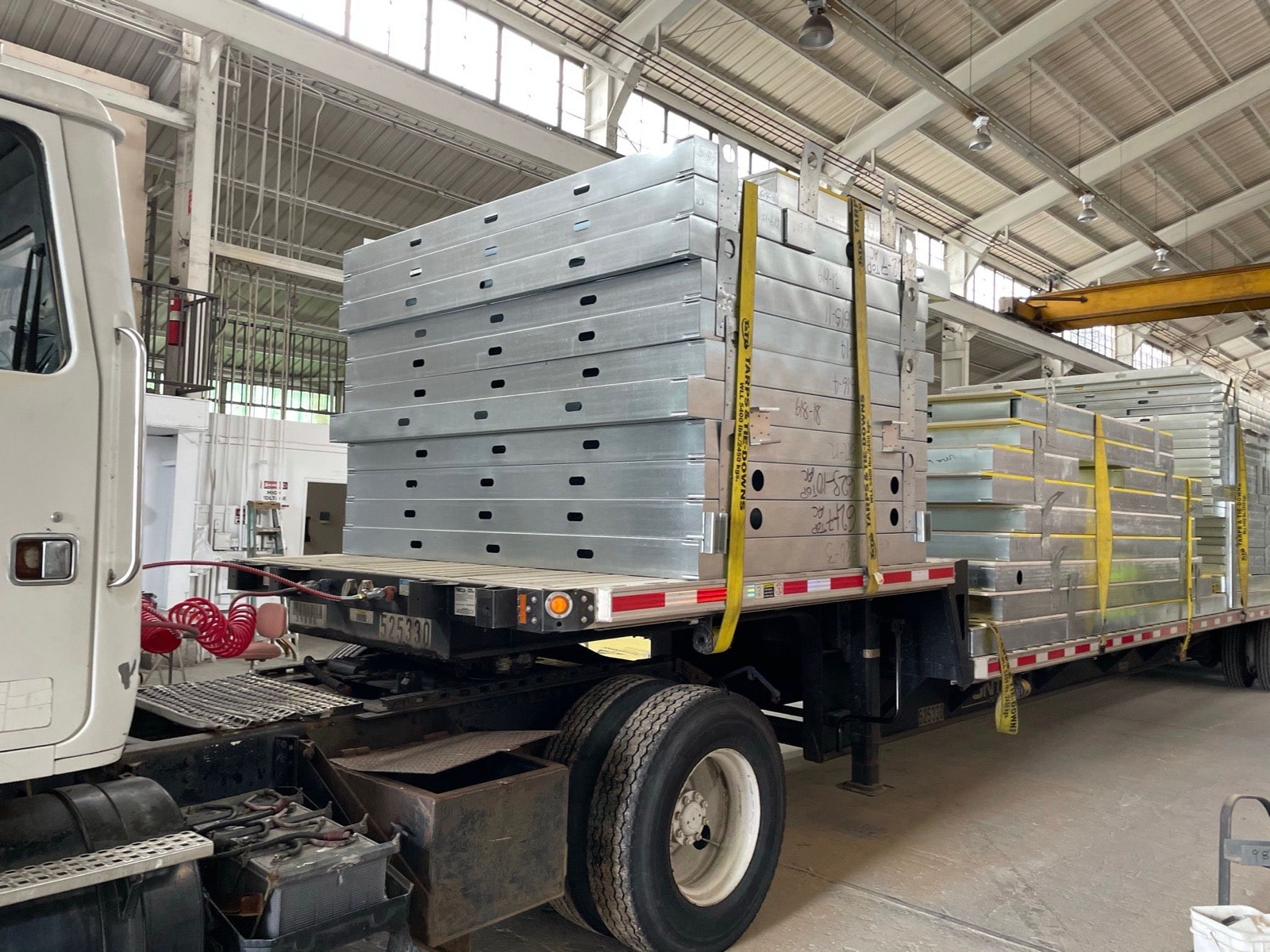 Panelized light gauge steel assemblies loaded on a flatbed at the factory for delivery.
