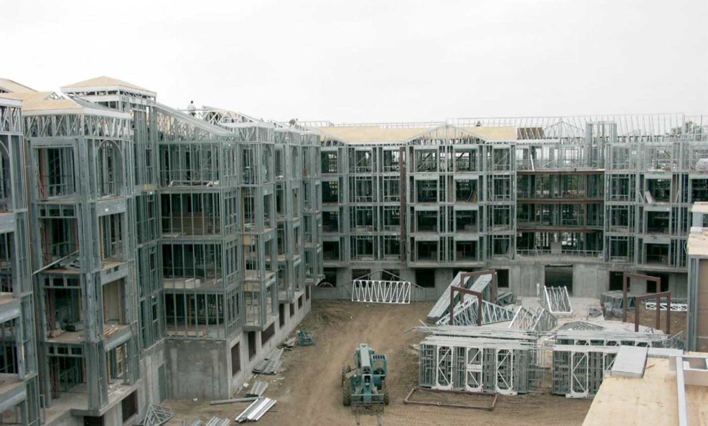 Light gauge steel framing of the Harvard Yard multifamily building, with prefabricated steel panels staged in the courtyard.